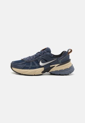 Blaue Mesh-Sneaker mit Wildlederakzenten, ausgestattet mit einer schwarzen und beigen Sohle, strukturiertem Overlay und einem silbernen Logo an der Außenseite.