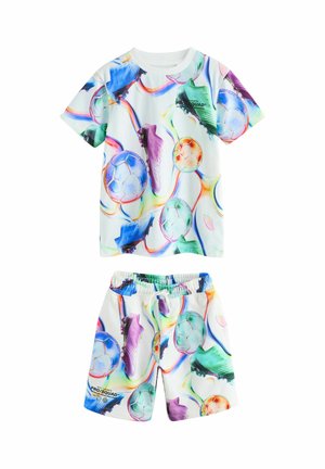 Súprava detskej košele s krátkym rukávom a kraťasov s farebnými vzormi futbalových lôpt a kopačiek na bielom pozadí.