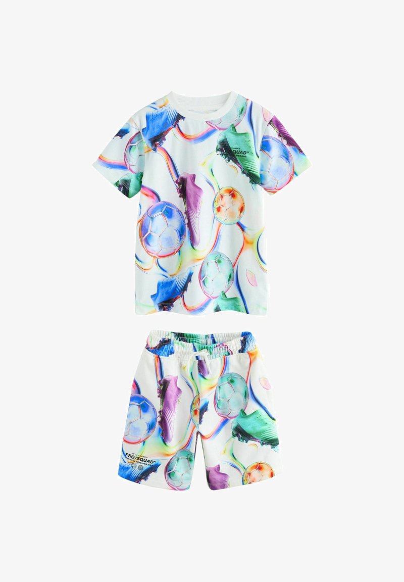 Ensemble pour enfants comprenant une chemise à manches courtes et un short, avec des motifs colorés de ballons de football et de crampons sur un fond blanc.