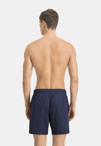 Bañador azul marino con cinturilla elástica; tejido ligero; diseño liso sin logotipos ni patrones visibles.