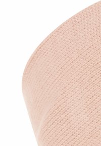 Close-up van een lichtroze gebreide stof met een zachte, textuur patroon en fijne steekdetails.