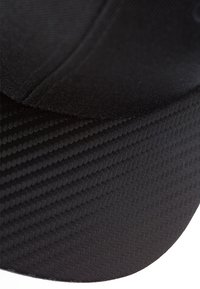 Căciulă neagră cu o parte superioară dintr-o țesătură netedă și o parte inferioară texturată, având un model de herringbone. Brăcile curbate și designul fără cusături.