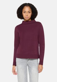 Sweter z golfem w kolorze bordowym o dopasowanym kroju, długich rękawach, ściągaczach na mankietach i u dołu. Miękka tekstura, lekka tkanina. Jeansy denimowe z srebrnymi akcentami.