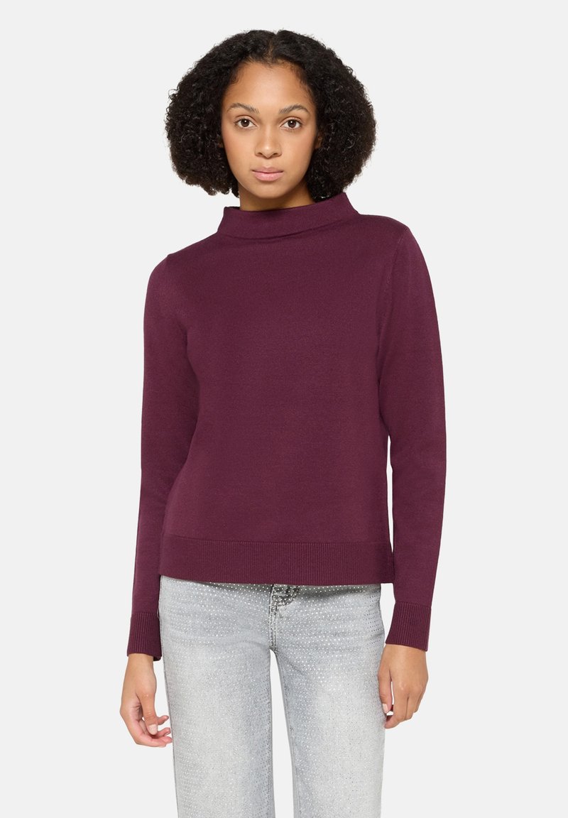 Sweter z golfem w kolorze bordowym o dopasowanym kroju, długich rękawach, ściągaczach na mankietach i u dołu. Miękka tekstura, lekka tkanina. Jeansy denimowe z srebrnymi akcentami.