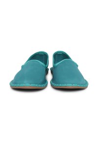 Scarpe slip-on turchesi con tomaia in tessuto liscio, design curvato, copertura minima alla caviglia e dettagli intrecciati lungo la suola.