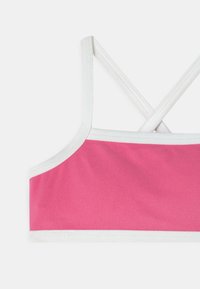 Sutiã desportivo rosa com acabamento branco, apresentando um design com costas cruzadas. Feito de um tecido liso e elástico com um acabamento limpo e simples.