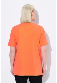 T-shirt a maniche corte in tessuto arancione brillante, con scollatura tondeggiante e vestibilità comoda, caratterizzato da una texture liscia e un design semplice.