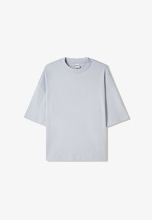 Light blue oversized t-shirt made of cotton, featuring a crew neck, short sleeves, and a plain design with no visible logos or patterns.