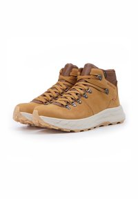 Gli scarponi da trekking in pelle marrone presentano occhielli metallici, lacci color beige e una suola in gomma color crema con texture per una migliore aderenza.