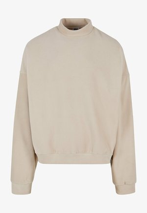 Beez värvi fliistee särk kõrge kaelusega, laia lõikega, madalate õlgadega ja ribaga mansettidega. Pehme tekstuur ja lihtne disain, ilma mustriteta.