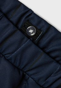 Tejido azul marino con una textura suave que presenta un botón claro y costuras en la cintura. Cintura elástica para mayor comodidad.