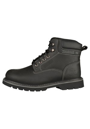Botas de trabajo de cuero negro con un collarín acolchado, ojales de metal y costuras en contraste. Presenta una suela de goma texturizada para mayor agarre.