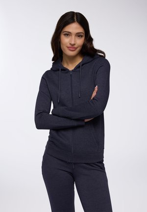 Granatowy hoodie wykonany z miękkiego materiału, z zamkiem błyskawicznym z przodu, kapturem ze sznurkiem i ściągaczami na rękawach. Połączony z pasującymi granatowymi spodniami.