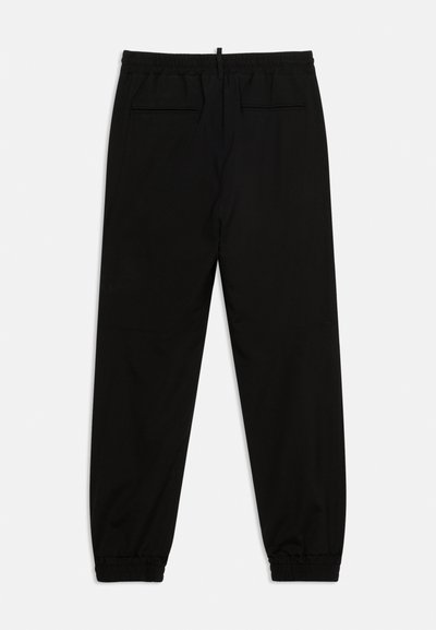 Pantalon noir fuselé avec taille et poignets élastiques, doté de deux poches à rabat à l'arrière, présenté à plat sur fond blanc.