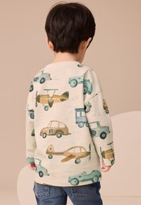 Jasna koszula z długim rękawem z wesołym nadrukiem różnych pojazdów, w tym samochodów i samolotów, w odcieniach zieleni, brązu i niebieskiego.