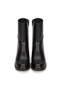 Botas de cuero negro hasta el tobillo con un acabado suave, punteras redondeadas y cremalleras laterales. Suelas negras resistentes con detalles de costura mínimos.