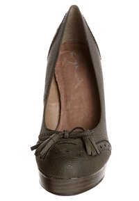 Olivgrön högklackad sko med en strukturerad läderöverdels, rund tå, dekorativa tofsar och en slät platåsåle. Interiören har en ljus foder.