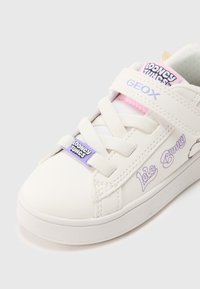 Weiße Sneaker aus synthetischem Material mit einem Klettverschluss, violetten Akzenten und "Lola Bunny"-Grafiken. Flache Gummisohle.