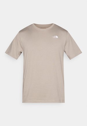 T-shirt en coton beige à manches courtes, col rond, avec un petit logo blanc sur le côté gauche de la poitrine. Texture lisse sans motifs.