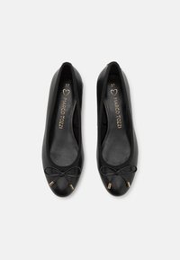 Ballerines en cuir noir, avec un bout arrondi, un petit nœud à l'avant, des accents dorés et des bords élastiques pour un ajustement sécurisé. Taille 37.