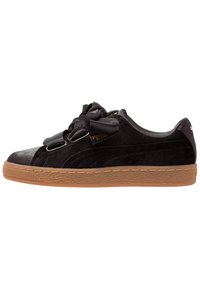 Černá semišová nízká teniska s širokými saténovými tkaničkami a texturovanou hnědou gumovou podrážkou, boční pohled.