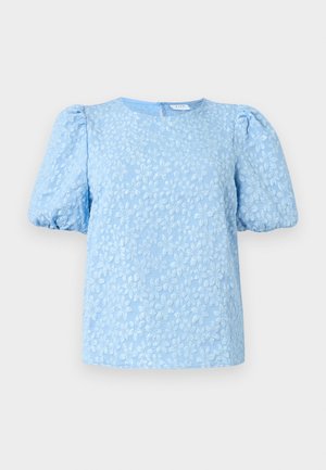 Lyseblå kortermet bluse med et teksturert blomstermønster, rund halslinning og voluminøse puffermer. Glidelås bak.