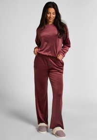 Lila loungewear set van zachte, textuurstof met een long-sleeve top en wijde broekspijpen, aangevuld met geruite slippers met een luchtige rand.