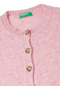 Růžový pletený kardigan s kulatým výstřihem, žebrovanými okraji a dřevěnými knoflíky vpředu. Na štítku je napsáno "UNITED COLORS OF BENETTON."
