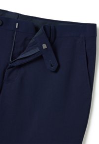 Marineblaue Anzughose mit kleinem Karomuster, teilweise geöffnetem Reißverschluss, Metallhakenverschluss und seitlichen Taschen, auf weißem Hintergrund sichtbar.