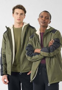 Olijfgroene, geïsoleerde jassen met capuchon, ritssluiting en fleece voering. Zwarte accenten op schouders en mouwen. Casual pasvorm.