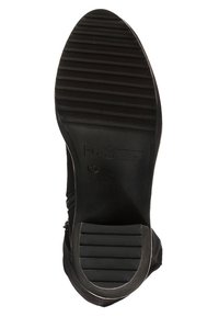 Suela de zapato negra con surcos verticales, material de goma, forma redondeada, logotipo en relieve y un borde ligeramente curvado para mejorar la tracción.