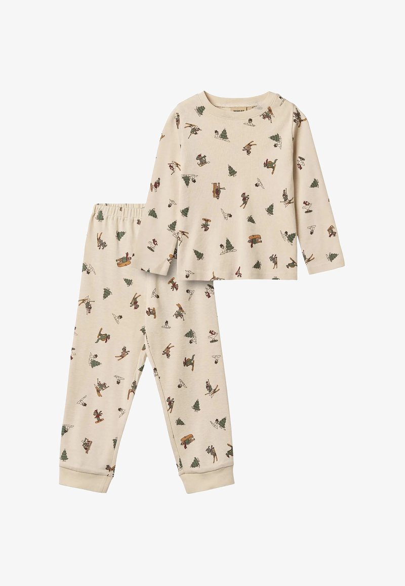 Ensemble beige comprenant un haut à manches longues et un pantalon avec une ceinture élastique, présentant de petits motifs imprimés de ski et d’arbres hivernaux.