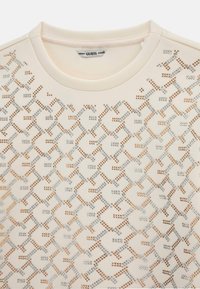 Felpa beige chiaro con scollo rotondo, caratterizzata da un motivo di borchie argento e rosa antico in un design geometrico sulla parte frontale.
