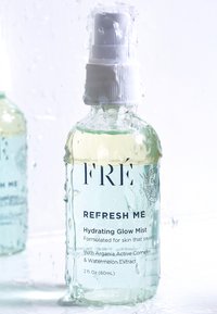 Przezroczysta butelka natryskowa z teksturowaną powierzchnią; jasnoszara ciecz wewnątrz; biały korek pompkowy; oznaczona napisem "ODŚWIEŻ MNIE" z informacjami o produkcie.