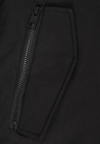 Tessuto nero con una tasca con zip dal finish testurizzato. La zip corre verticalmente lungo il bordo, migliorando la funzionalità.