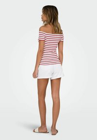 Röd- och vitrandig off-the-shoulder topp i kombination med vita shorts, avslappnad design, lättviktig tyg och platta sandaler.