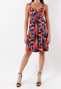 Robe multicolore sans manches présentant un motif floral en rouge, vert et bleu. Elle dispose de bretelles ajustables ornées d'accents circulaires en métal.