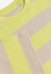 Bavlnen�é tričko s krátkym rukávom s širokými žltými a béžovými vodorovnými pruhmi. Žebrovaný výstrih a jemné švy pre detailný vzhľad.