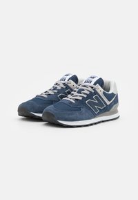 Dunkelblaue Sport Schuhe mit einem Obermaterial aus Mesh und Wildleder, grauen Akzenten und einer dicken Gummisohle mit strukturiertem Profil. Klassisches Schnürdesign.