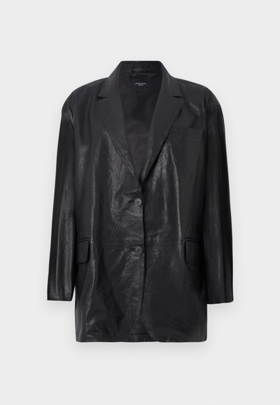 Blazer en cuir noir avec une finition légèrement texturée, des revers crantés, une fermeture à deux boutons et une poche poitrine unique. Coupe décontractée.