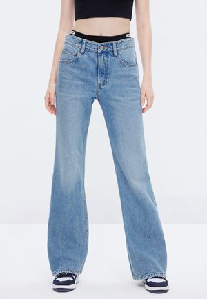 Vaaleansiniset leveälahkeiset farkut korkealla vyötäröllä, etutaskuilla ja haalistuneella denim-tekstuuri. Sisältää mustan brändätyn vyötärönauhan.