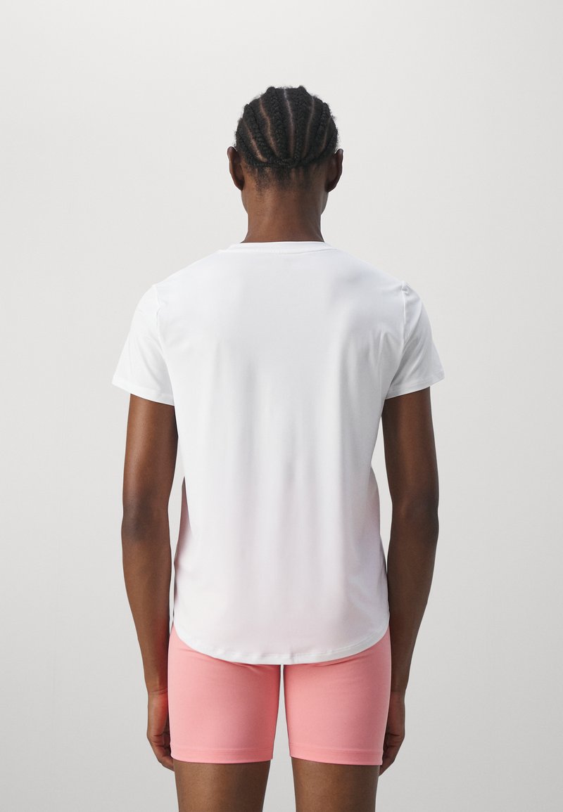 Weißes Sport-T-Shirt mit kurzen Ärmeln, glatter Textur und abgerundetem Saum, kombiniert mit enganliegenden pinken Shorts. Keine Muster oder Akzente.