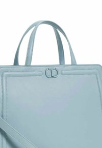 Borsa tote in pelle azzurro chiaro con manici corti, forma rettangolare strutturata e un logo goffrato discreto sulla chiusura.