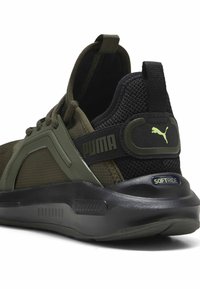 Zielone buty sportowe z siateczkową cholewką, teksturowanymi akcentami i czarną gumową podeszwą. Zawierają logo Pumy oraz regulowany pasek na pięcie.