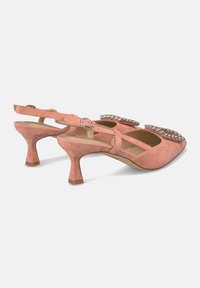 Pink suede slingback shoes with a low heel, featuring embellished straps adorned with clear rhinestones on a pointed toe design.