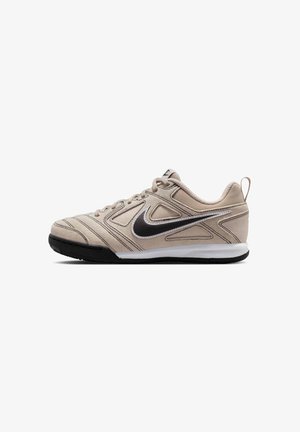 Baskets Nike beige avec logo Swoosh noir, semelle avant noire, semelle intermédiaire blanche, design à lacets et languette au talon.