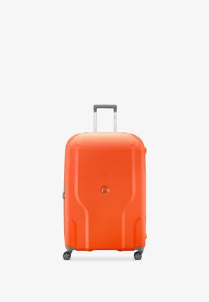 Valigia rigida di colore arancione brillante con una superficie texturizzata, dotata di manico retrattile e quattro ruote girevoli per una facile manovrabilità.