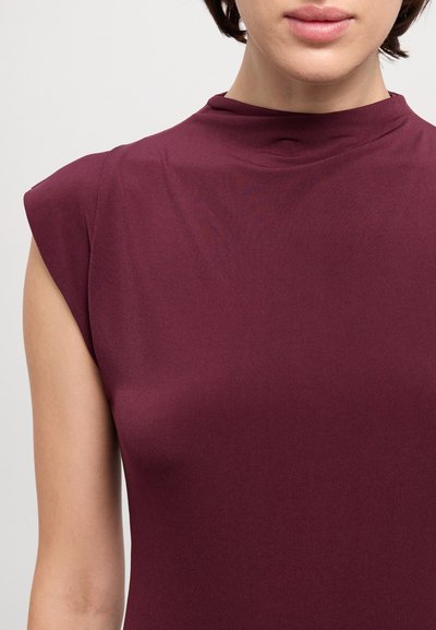 Μπορντό αμάνικο τοπ με ψηλό λαιμό και λείο, ελαστικό ύφασμα. Διαθέτει στενή γραμμή και ήπια γυαλάδα.