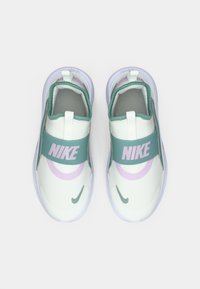 Svijetlozelene slip-on tenisice s širokom tirkiznom trakom, ružičastim Nike logom i teksturiranim mrežastim gornjištem. Ljubičaste akcenti sa strane.