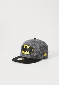 Graue Kappe mit schwarzem Schirm, die ein auffälliges gelb-schwarzes Batman-Logo aufweist, verziert mit einem Batman-Muster auf dem Stoff.